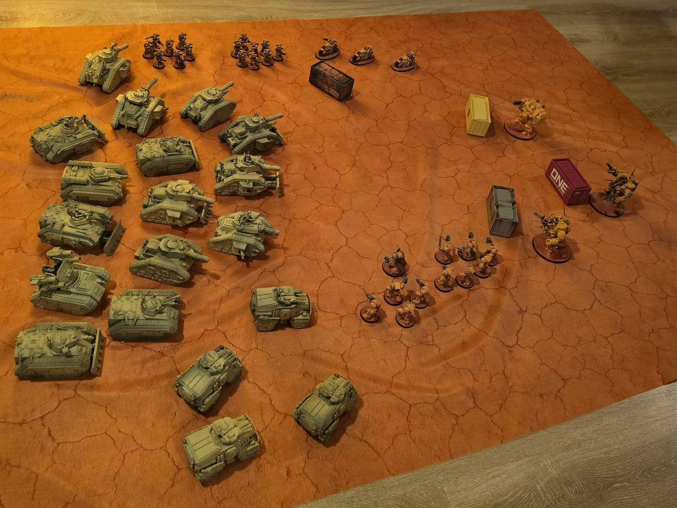 Collection of miniature tanks and vehicles on a textured orange surface